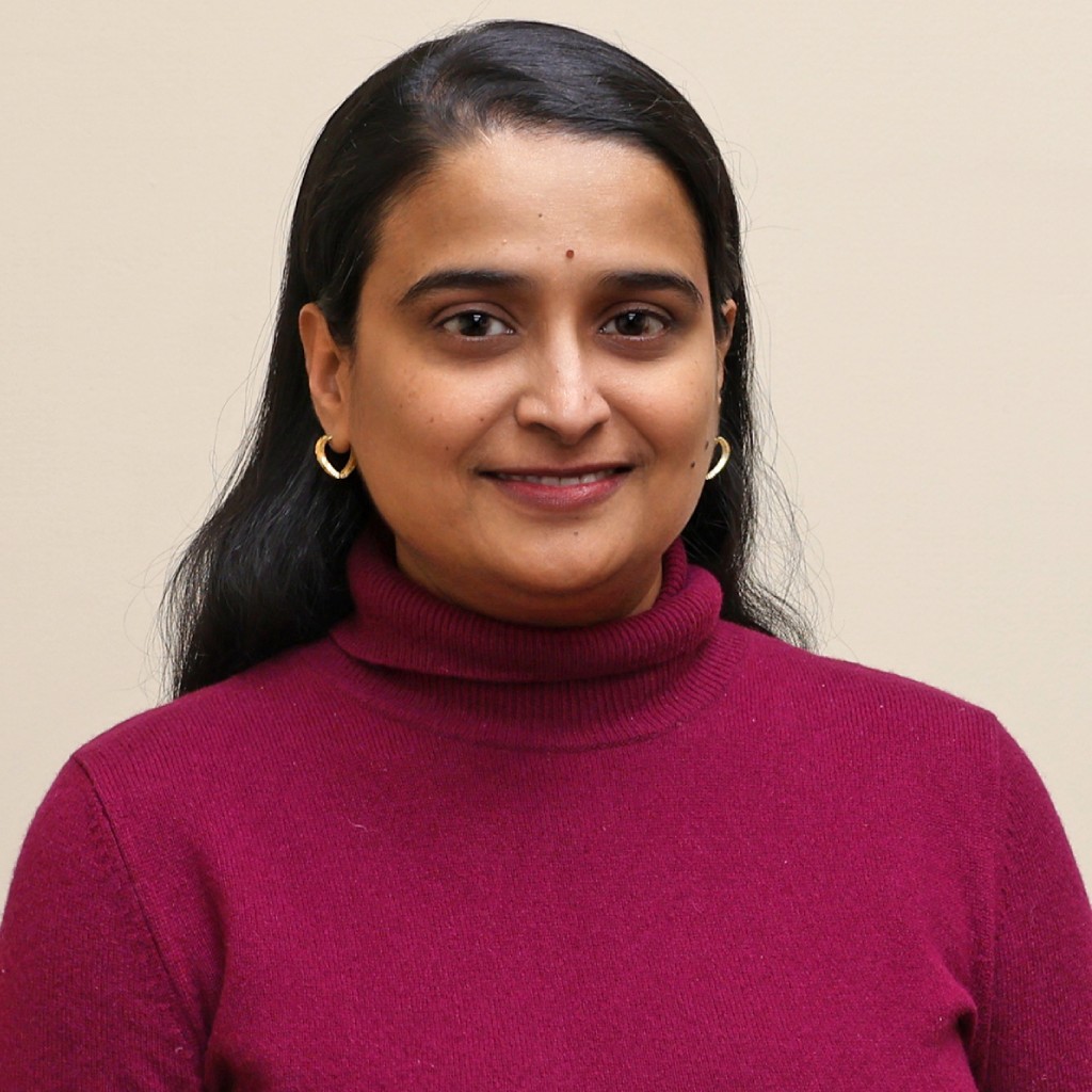 Portrait of a woman in a maroon turtleneck against a plain background.